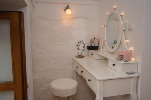 een badkamer met een witte wastafel met een spiegel en een kruk bij Kaleta in Vodice