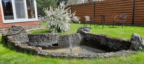 a stone fountain in the yard of a house at Verkių Namelis in Vilnius