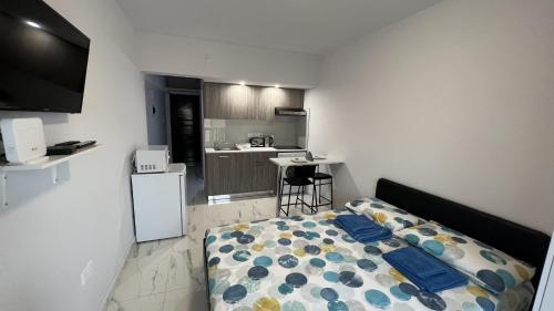 a small bedroom with a bed and a kitchen at Elena Court Apartments in Ayia Napa