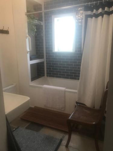 een badkamer met een bad, een raam en een douche bij Harvest Moon-ROOMS ONLY in Doolin