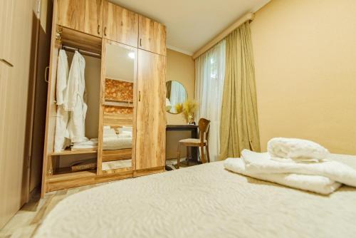 ein Schlafzimmer mit einem großen Bett und einem Spiegel in der Unterkunft Garden House in Tbilisi City