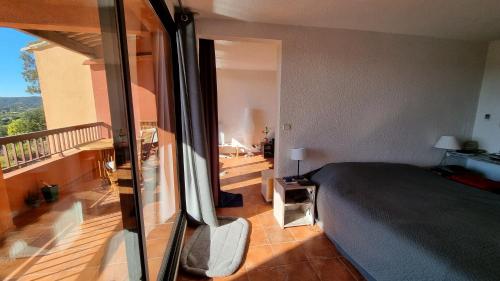 a bedroom with a bed and a balcony at Les Terrasses du Mirage grand T2 in Bormes-les-Mimosas