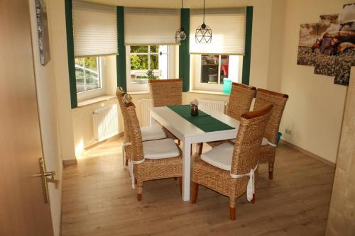 ein Esszimmer mit einem Tisch und Korbstühlen in der Unterkunft Ferienwohnung Waldblick in Brilon