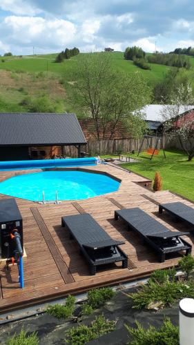 una terraza de madera con vistas a una piscina. en Domek w dolinie en Berest