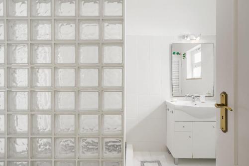 bagno con parete in vetro, lavandino e specchio di Casa Maresia - Apartamento 2 quartos e piscina - Praia Carvoeiro a Carvoeiro