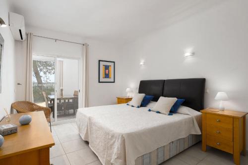 a bedroom with a bed with blue pillows and a desk at Casa Maresia - Apartamento 2 quartos e piscina - Praia Carvoeiro in Carvoeiro