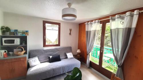 ein Wohnzimmer mit einem Sofa und einem Fenster in der Unterkunft Escapade Au Calme De La Rivière in Métabief