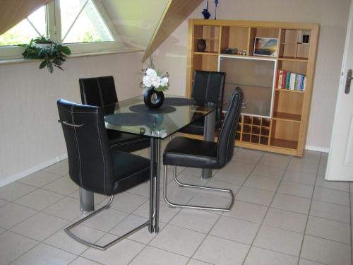 a dining room with a table and black chairs at Ländlich ruhig 10 km vor Rostock in Dummerstorf