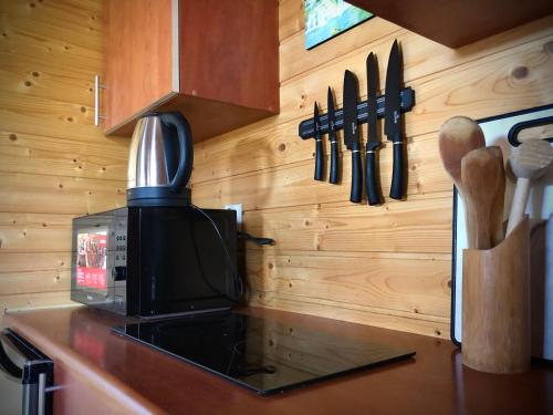 a kitchen with a counter with a microwave and knives at Domki letniskowe SILVER in Jarosławiec