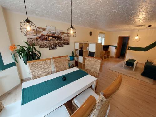 ein Esszimmer und ein Wohnzimmer mit einem Tisch und Stühlen in der Unterkunft Ferienwohnung Waldblick in Brilon