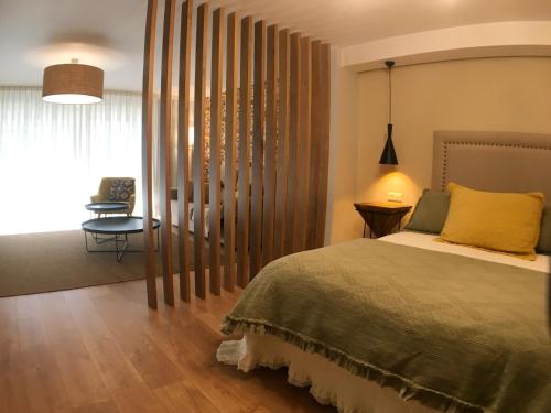 a bedroom with a bed and a window with a chair at AD Loft apartment, Centro Cambados in Cambados