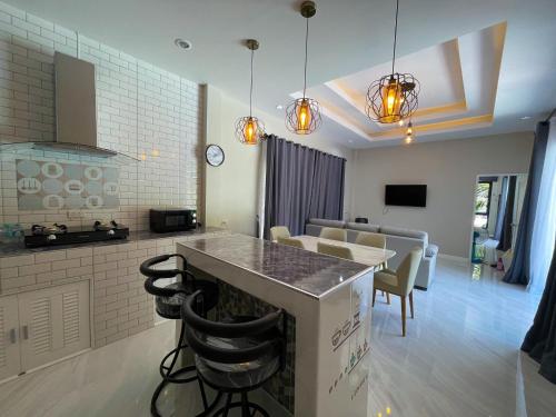 a kitchen and living room with a table and chairs at Pool Villa Nita in Ban Na Klang