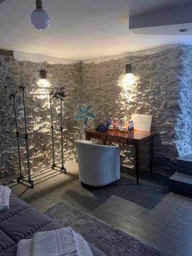 a bathroom with a tub and a desk and a stone wall at Bed & Breakfast StudioArcodia- in San Marco dʼAlunzio