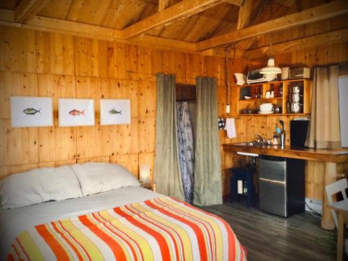a bedroom with a bed in a wooden room at Café Acadien in Bonaventure
