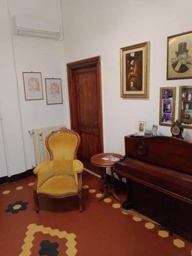a living room with a chair and a piano at Casa con Vista - Border House - Pontremoli in Pontremoli