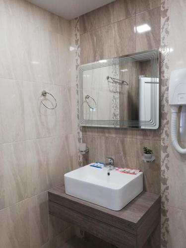a bathroom with a white sink and a mirror at Хотел Бялата роза in Shipka