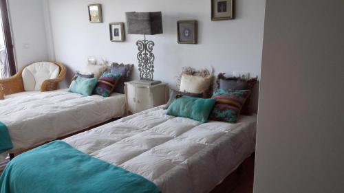 ein Zimmer mit 2 Betten mit Kissen darauf in der Unterkunft duplex de lujo en medio del paraiso in Teira