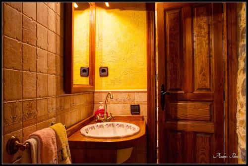 y baño con lavabo y espejo. en La Borda de Mery., en Charo