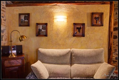 a living room with a couch and pictures on the wall at La Borda de Mery. in Charo