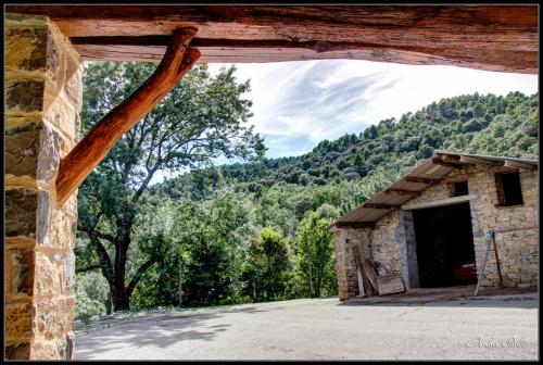 a window in a stone building with a mountain at La Borda de Mery. in Charo