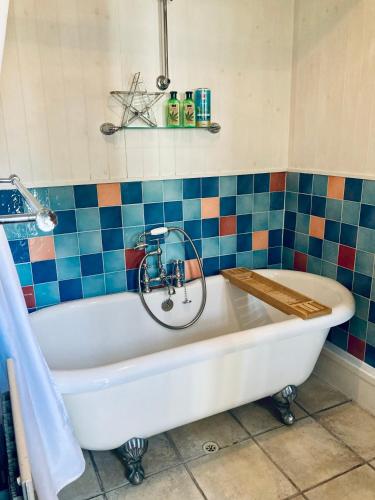 a white bath tub with a bike in a bathroom at Castle View Cottage in Lincoln