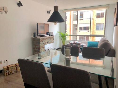 uma sala de estar com uma mesa de vidro e um sofá em Fantástica Habitación Privada Colina em Bogotá