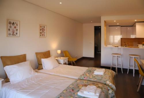 a hotel room with a bed and a kitchen at Cascais By the Sea in Cascais
