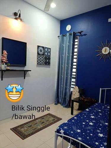 a blue room with a bed and a television at Salju Mewah Homestay in Kampong Sungai Che Lias