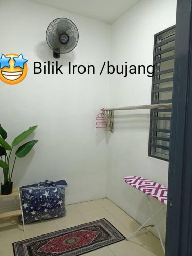 a room with a fan and a rug on the floor at Salju Mewah Homestay in Kampong Sungai Che Lias