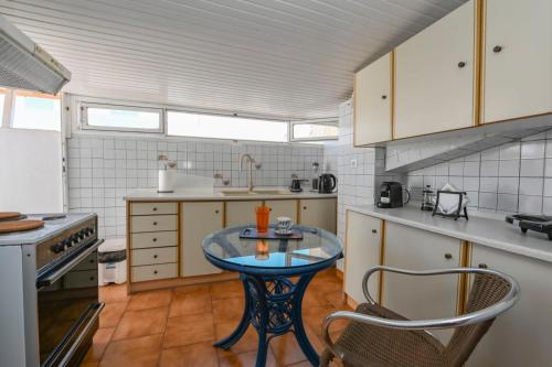 a kitchen with a glass table and a sink at Studio rene 4 in Tinos