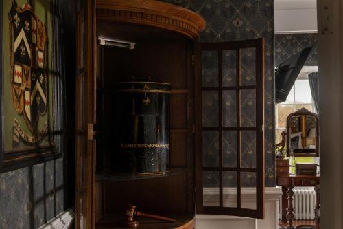 a wooden cabinet with a bucket in a room at Plas Dinas Country House in Caernarfon