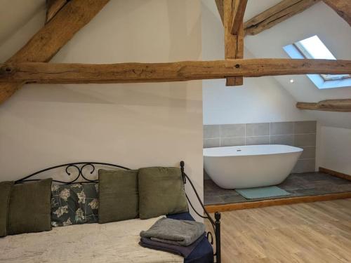1 dormitorio con bañera en el ático en Trois Mousquetaires Gîte en Saint-Dizier-Leyrenne