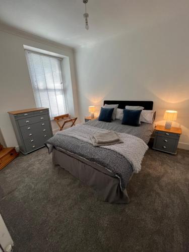 a bedroom with a large bed with blue pillows at Town House,Walking Distance To Beach,Town,Harbour in Torquay