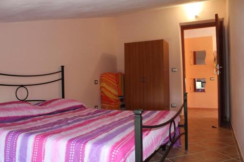 een slaapkamer met een bed en een houten kast bij Olmedo Casa Vacanze in Olmedo