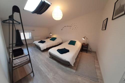 - une chambre avec 2 lits et une télévision dans l'établissement Etage d'une agréable maison de ville, à Bourg-Saint-Andéol