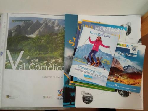 three books sitting on top of a table at B&B Il Tulipano in San Pietro di Cadore