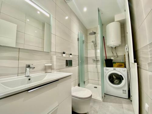 een badkamer met een wastafel en een wasmachine bij **Fresh and cosy appt with Pool, Fiber, SportTV** in Albufeira