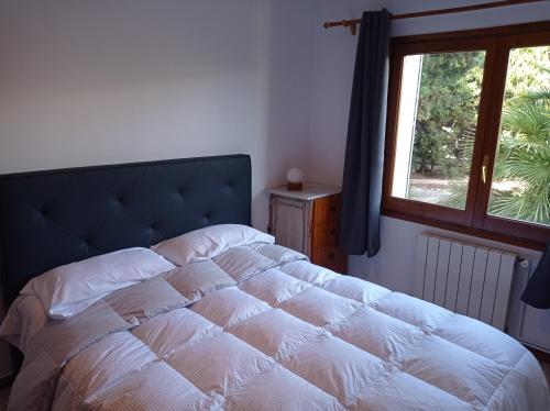 - une chambre avec un grand lit et une fenêtre dans l'établissement Casa de la Playa en Torredembarra, à Creixell