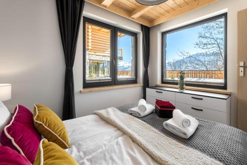 a bedroom with a bed with two towels on it at Osada Gubałówka na Polanie Pająkówka & SPA in Kościelisko