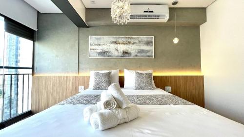- une chambre avec un lit et des serviettes dans l'établissement Haus Stay . Luxo . Vitralli Moema, à São Paulo