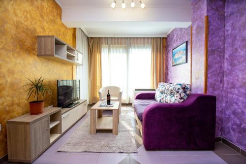 a living room with a purple couch and a tv at SunSea Apartments in Budva
