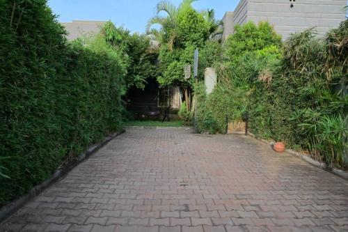 a brick alley with bushes and a building at Cheerful 3-Bedroom Home in a Family Setting in Kira