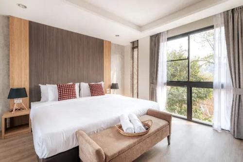 a bedroom with a large bed and a large window at Reiz - Private Residence in Chiang Mai