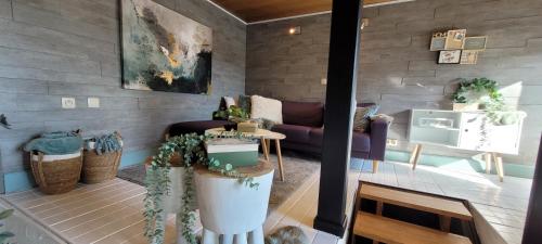 a living room with a purple couch and some plants at Sea-renity 23 met sauna en jacuzzi in Eggewaartskapelle