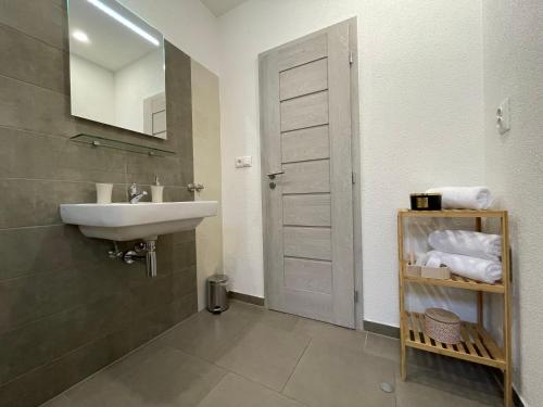 a bathroom with a sink and a mirror at City Apartments in Liptovský Mikuláš