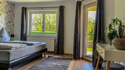a bedroom with a bed and two windows at Wohlfühloase in Eisenbach