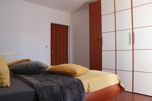 a bedroom with a bed with pillows and cabinets at Nona Lili apartment in Izola
