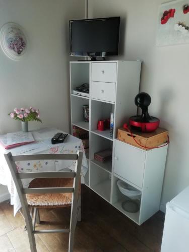 a room with a desk and a tv on a shelf at La Borie du Chevrier in Sainte-Croix-de-Beaumont