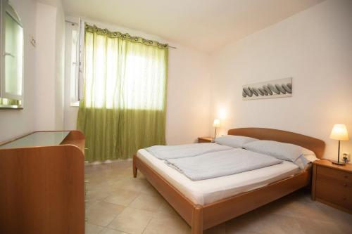 1 dormitorio con 1 cama y cortina verde en Guesthouse Seaview, en Brela