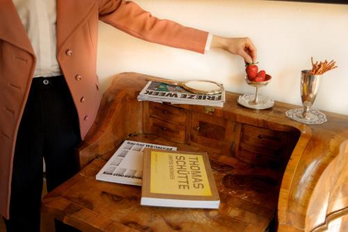 a man is holding an apple on a wooden table at Weisses Rössl in Caldaro